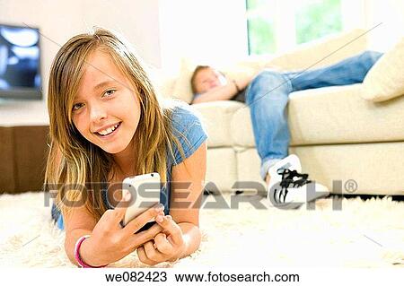 Stock Image - boy, cell phone, carpet, brother, at-home. Fotosearch