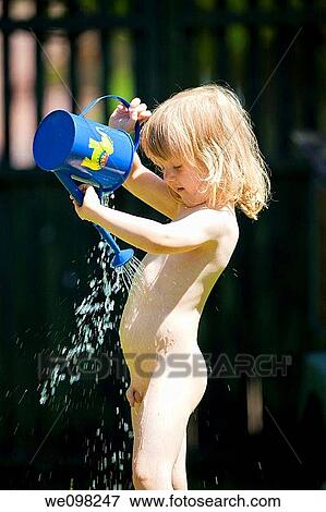 boy pouring water on himsef from watering-can during hot summer View Large Photo Image Stock Photo - boy pouring water on himsef from watering-can during hot summer. Fotosearch