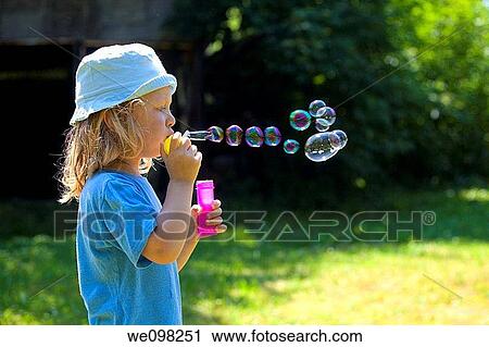 boy with long blond hair blowing soap bubbles outdoors View Large Photo Image Stock Image - boy with long blond hair blowing soap bubbles outdoors. Fotosearch