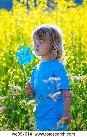 boy with long blond hair holding pinwheel in canola field View Large Photo Image Picture - boy with long blond hair holding pinwheel in canola field. Fotosearch
