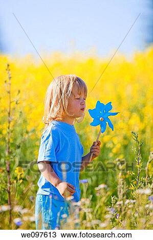 boy with long blond hair holding pinwheel in canola field View Large Photo Image Stock Image - boy with long blond hair holding pinwheel in canola field. Fotosearch