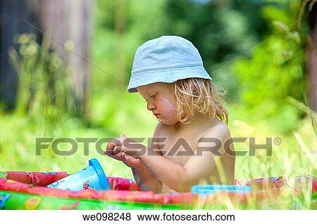 boy with long blond hair in plastic pool in the garden View Large Photo Image Stock Photo - boy with long blond hair in plastic pool in the garden. Fotosearch