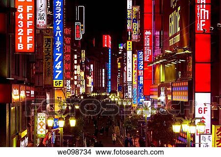 Busy scene at night with many bright, glowing signs and people walking in street in Shinjuku, Tokyo, Japan View Large Photo Image Picture - Busy scene at night with many bright, glowing signs and people walking in street in Shinjuku, Tokyo, Japan. Fotosearch
