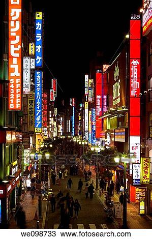 Busy scene at night with many bright, glowing signs and people walking in street in Shinjuku, Tokyo, Japan View Large Photo Image Stock Image - Busy scene at night with many bright, glowing signs and people walking in street in Shinjuku, Tokyo, Japan. Fotosearch