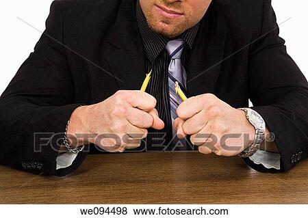 Caucasian businessman setting at a desk and looking very angry and frustrated View Large Photo Image Stock Photo - Caucasian businessman setting at a desk and looking very angry and frustrated. Fotosearch
