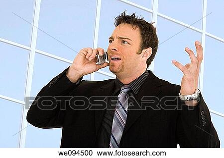 Caucasian businessman standing and talking on the cell phone and angry View Large Photo Image Stock Image - Caucasian businessman standing and talking on the cell phone and angry. Fotosearch