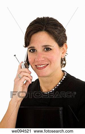 Stock Image - Caucasian businesswoman and smiling and talking on a cell phone while standing on a white background. Fotosearch