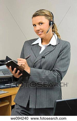 Caucasian businesswoman in her early 30s standing at a desk going over a day planner View Large Photo Image Stock Image - Caucasian businesswoman in her early 30s standing at a desk going over a day planner. Fotosearch