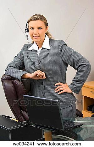 Caucasian businesswoman in her early 30s standing at a desk and smiling View Large Photo Image Stock Image - Caucasian businesswoman in her early 30s standing at a desk and smiling. Fotosearch