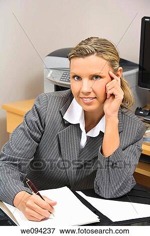 Caucasian businesswoman in her early 30s setting at a desk going over a day planner View Large Photo Image Stock Photo - Caucasian businesswoman in her early 30s setting at a desk going over a day planner. Fotosearch