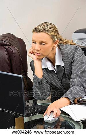 Caucasian businesswoman in her early 30s setting at a desk working with a laptop computer View Large Photo Image Stock Photograph - Caucasian businesswoman in her early 30s setting at a desk working with a laptop computer. Fotosearch