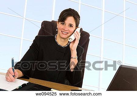 Stock Photography - Caucasian businesswoman setting a desk and smiling. Fotosearch