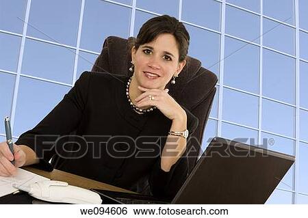 Caucasian businesswoman setting at a desk and smiling View Large Photo Image Stock Photograph - Caucasian businesswoman setting at a desk and smiling. Fotosearch