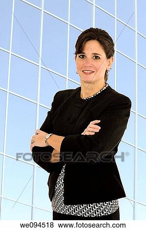 Caucasian businesswoman smiling while standing with her arms folded across her chest View Large Photo Image Stock Photo - Caucasian businesswoman smiling while standing with her arms folded across her chest. Fotosearch