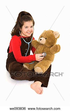 Caucasian child using a stethoscope to pretend she is listening to her teddybear's heart beat View Large Photo Image Stock Photograph - Caucasian child using a stethoscope to pretend she is listening to her teddybear's heart beat. Fotosearch