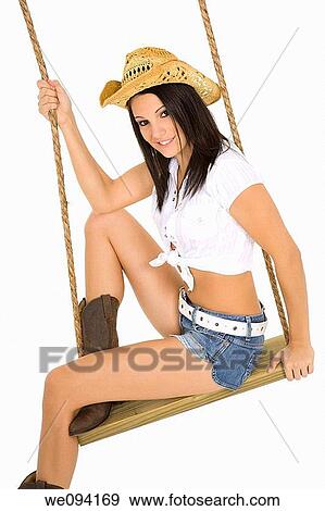 Caucasian cowgirl in wooden swing on white background View Large Photo Image Stock Photo - Caucasian cowgirl in wooden swing on white background. Fotosearch