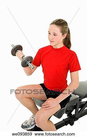 Stock Photo - Caucasian preteen female lifting weights using a dumbbell on a white background. Fotosearch