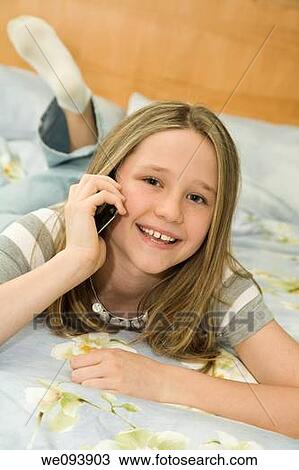 Caucasian preteen girl laying in bed talking on a cell phone View Large Photo Image Stock Image - Caucasian preteen girl laying in bed talking on a cell phone. Fotosearch