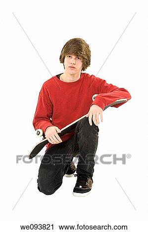 Caucasian teenager holding a skateboard on a white background View Large Photo Image Stock Image - Caucasian teenager holding a skateboard on a white background. Fotosearch