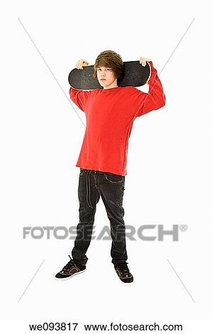 Caucasian teenager holding a skateboard on a white background View Large Photo Image Stock Photo - Caucasian teenager holding a skateboard on a white background. Fotosearch