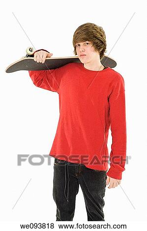 Caucasian teenager holding a skateboard on a white background View Large Photo Image Stock Photo - Caucasian teenager holding a skateboard on a white background. Fotosearch