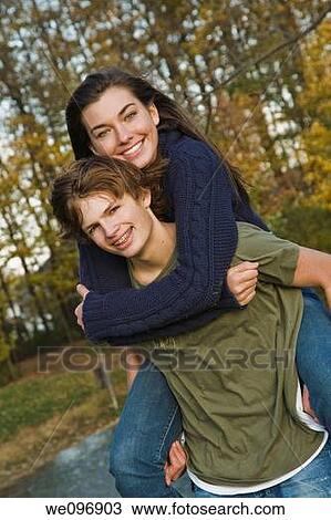 Caucasian teens one male and one females horsing around in a park riding piggy back View Large Photo Image Stock Image - Caucasian teens one male and one females horsing around in a park riding piggy back. Fotosearch