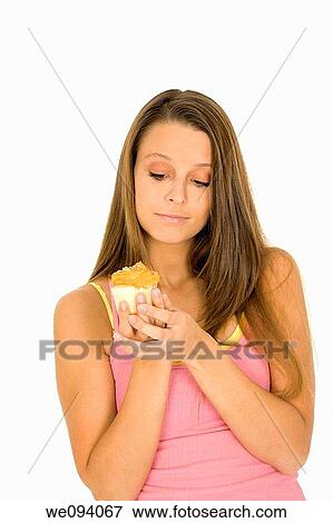 Caucasian woman eating a chocolate cupcake on a white background View Large Photo Image Stock Photo - Caucasian woman eating a chocolate cupcake on a white background. Fotosearch