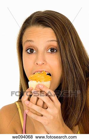 Caucasian woman eating a chocolate cupcake on a white background View Large Photo Image Stock Photo - Caucasian woman eating a chocolate cupcake on a white background. Fotosearch