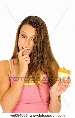 Caucasian woman eating a chocolate cupcake on a white background View Large Photo Image Stock Photography - Caucasian woman eating a chocolate cupcake on a white background. Fotosearch