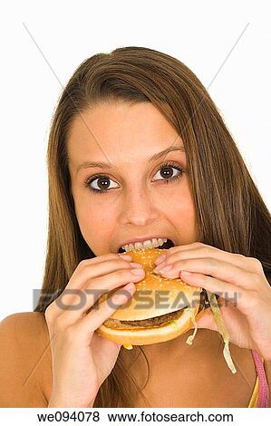 Stock Photo - Caucasian woman eating a hambuger on a white background. Fotosearch