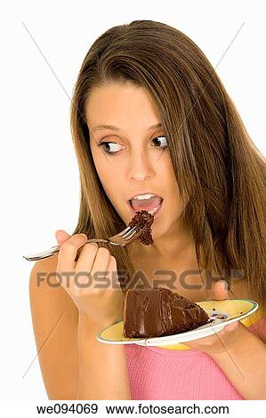 Caucasian woman eating a slice of chocolate cake on a white background View Large Photo Image Stock Photo - Caucasian woman eating a slice of chocolate cake on a white background. Fotosearch