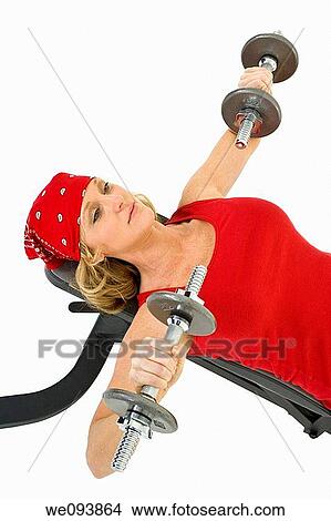 Caucasian woman in early 40s lifting weights using a dumbbell on a white background View Large Photo Image Picture - Caucasian woman in early 40s lifting weights using a dumbbell on a white background. Fotosearch