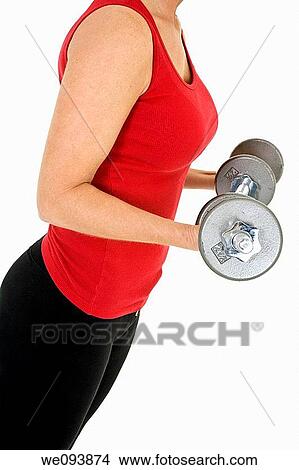 Picture - Caucasian woman in early 40s lifting weights using a dumbbell on a white background. Fotosearch
