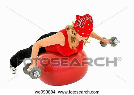 Caucasian woman in early 40s lifting weights using a excerise ball and dumbbell on a white background View Large Photo Image Picture - Caucasian woman in early 40s lifting weights using a excerise ball and dumbbell on a white background. Fotosearch