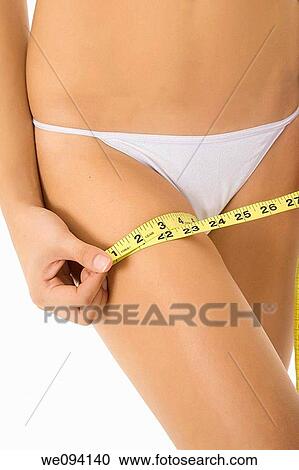 Caucasian woman measuring her leg on a white background View Large Photo Image Stock Image - Caucasian woman measuring her leg on a white background. Fotosearch