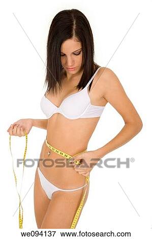 Caucasian woman measuring her waist on a white background View Large Photo Image Stock Photo - Caucasian woman measuring her waist on a white background. Fotosearch