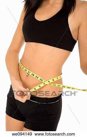 Caucasian woman measuring her waist on a white background View Large Photo Image Stock Photo - Caucasian woman measuring her waist on a white background. Fotosearch
