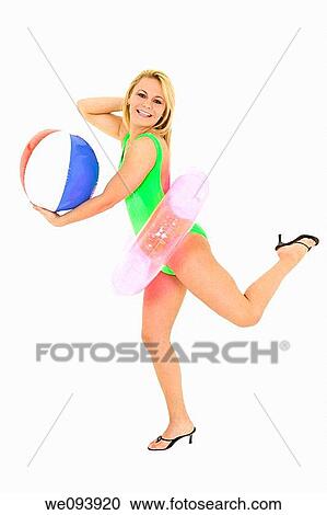 Caucasian woman standing on a white background in a swimsuit holding a beach toys and smiling View Large Photo Image Stock Image - Caucasian woman standing on a white background in a swimsuit holding a beach toys and smiling. Fotosearch