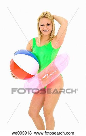 Caucasian woman standing on a white background in a swimsuit holding a beach toys and smiling View Large Photo Image Stock Photo - Caucasian woman standing on a white background in a swimsuit holding a beach toys and smiling. Fotosearch