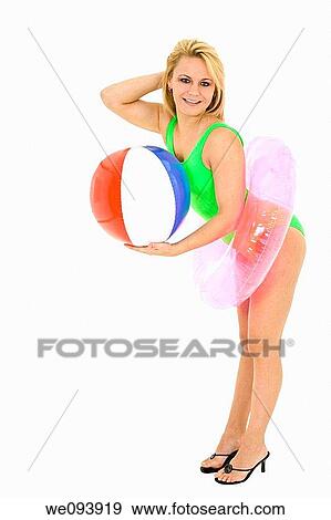 Caucasian woman standing on a white background in a swimsuit holding a beach toys and smiling View Large Photo Image Stock Photo - Caucasian woman standing on a white background in a swimsuit holding a beach toys and smiling. Fotosearch
