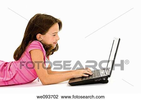 Child laying on a white background working on laptop computer View Large Photo Image Stock Image - Child laying on a white background working on laptop computer. Fotosearch