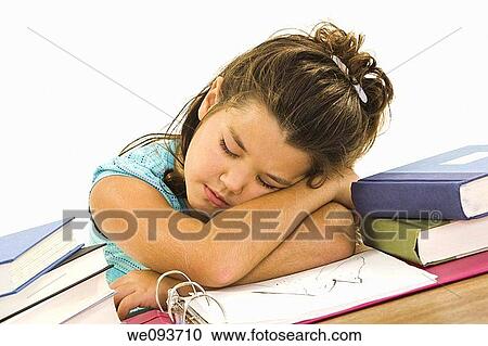 Stock Image - Child sleeping while working on homework on white background. Fotosearch