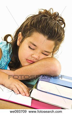 Stock Photo - Child sleeping while working on homework on white background. Fotosearch