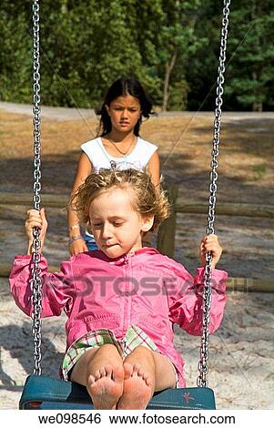 Children swinging View Large Photo Image Stock Photograph - Children swinging. Fotosearch
