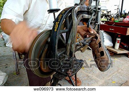 China guangxi yangshuo hand of a street shoemaker turning a manual machine and reseeding a sandal View Large Photo Image Stock Image - China guangxi yangshuo hand of a street shoemaker turning a manual machine and reseeding a sandal. Fotosearch