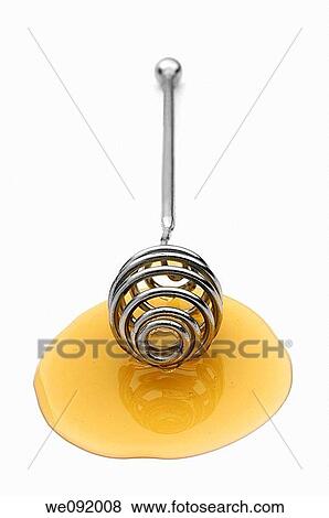 Stock Photo - Clear honey on drizzler. Fotosearch