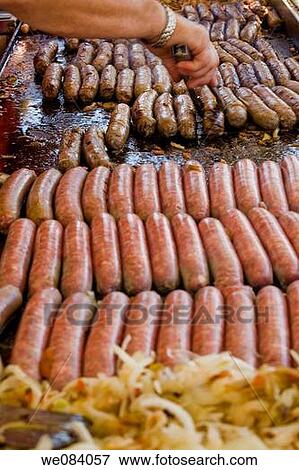 Close-up of a man's hand turning sausages on a grill at a fair. View Large Photo Image Stock Photo - Close-up of a man's hand turning sausages on a grill at a fair.. Fotosearch