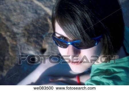 Close-up of a young woman wearing sunglasses. View Large Photo Image Stock Image - Close-up of a young woman wearing sunglasses.. Fotosearch