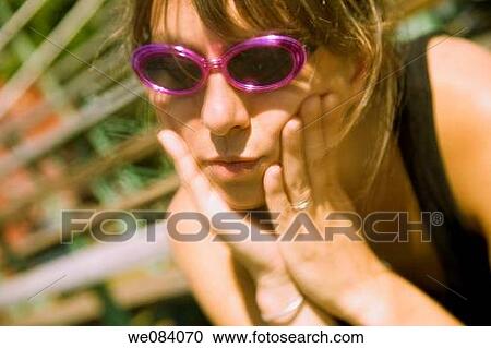 Close-up of a young woman, wearing sunglasses, sitting on empty bleachers at a fair View Large Photo Image Stock Image - Close-up of a young woman, wearing sunglasses, sitting on empty bleachers at a fair. Fotosearch