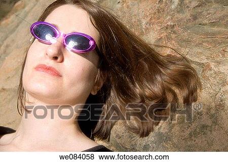 Close-up of a young woman wearing sunglasses View Large Photo Image Stock Photo - Close-up of a young woman wearing sunglasses. Fotosearch